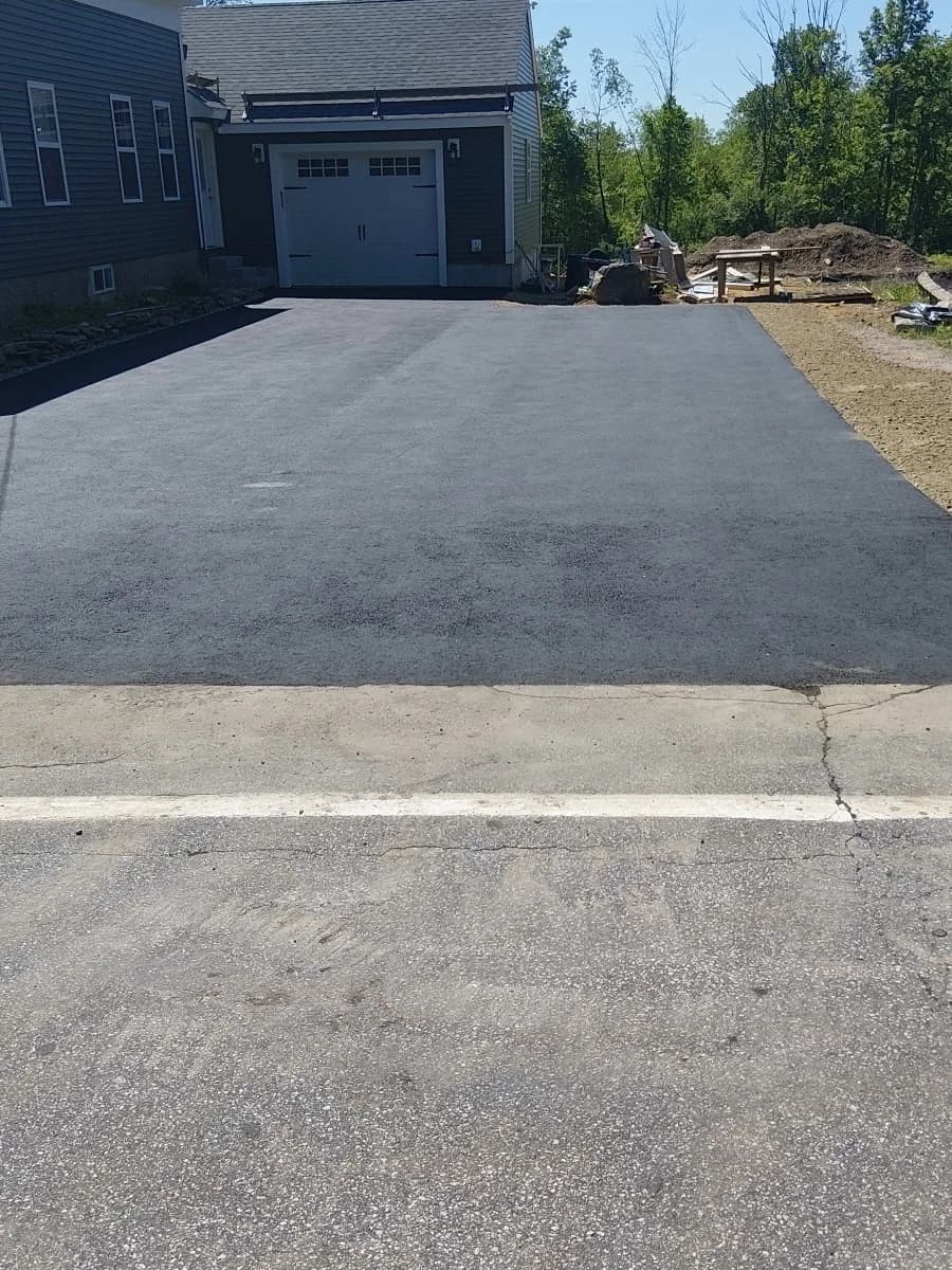 A new asphalt driveway apron laid to the garage of a newly built home